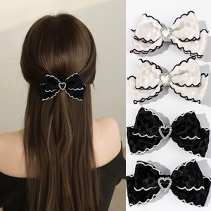 Détail de barrettes en velours avec strass en forme de cœur et bordures ondulées chic