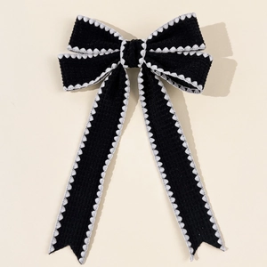 Detail of vintage French black bow hair clip with elegant white lace embroidery edges