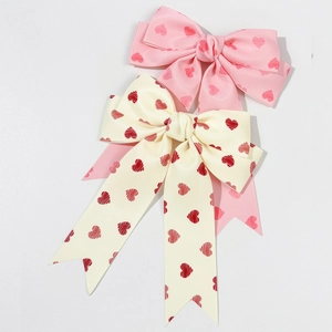 Sweet pink and cream bow hair clips with red heart patterns for a princess style
