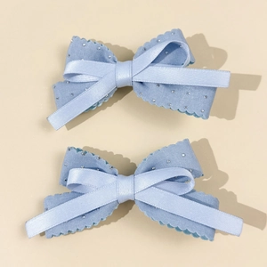 Detail of light blue bow hair clips with rhinestones and scalloped ribbon edges