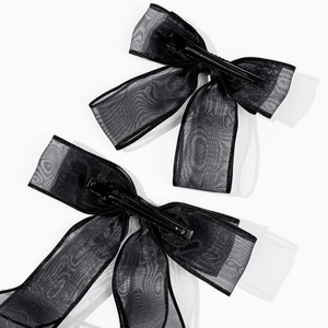 Detail shot of black organza ribbon hair bows with transparent mesh texture and metal clips