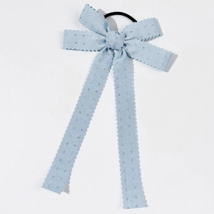 Détail du chouchou nœud bleu clair avec paillettes argentées et bords dentelés ondulés