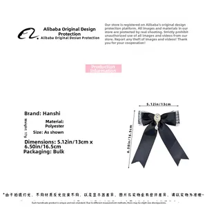 Detail of lace bow hair clip with faux pearls and rhinestones on black polyester fabric
