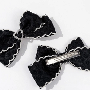 Détail des barrettes nœuds en velours noir avec dentelle et strass en cœur