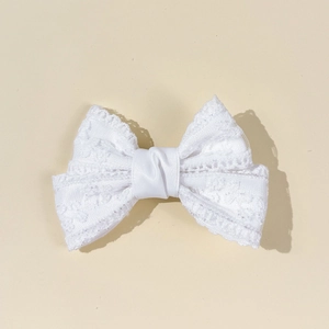 Detailed macro view of the intricate white crochet lace floral texture on the hair clip bow