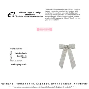Detailed texture of grey fabric bow hair clip with metallic thread and metal duckbill clip