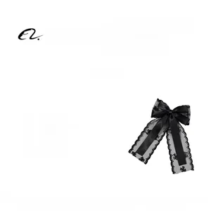 Detail view of elegant black lace bow hair clip with silk ribbons and floral texture