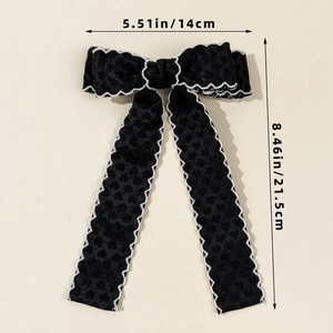 Vue détaillée d'un nœud papillon noir avec bords ondulés blancs et texture à pois