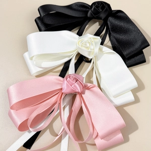 Three-pack satin bow hair clips in black, white, and pink with rose floral accents