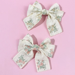 Elegant floral bow hair clips in pink and yellow with gold-edged texture for women