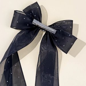 Détail d'un nœud papillon en tulle noir avec strass et pince crocodile en métal robuste