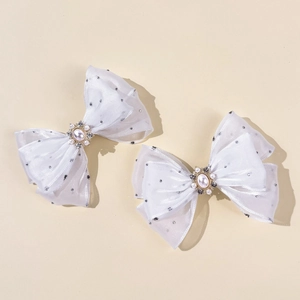 Gedetailleerde macro-opname van witte mesh haarklemmen met stippen, parels en strassteen
