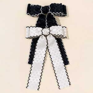 Détail d'un nœud papillon noir et blanc avec jacquard cœur et bords ondulés