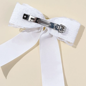 Detailed back view of white lace bow hair clip showing silver metal spring fastener