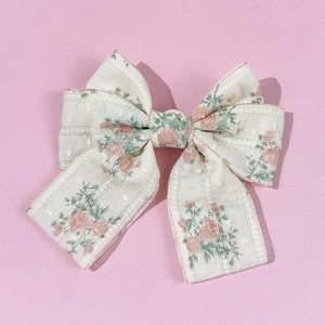 Detailed macro view of the floral bow hair clip with translucent ivory mesh fabric
