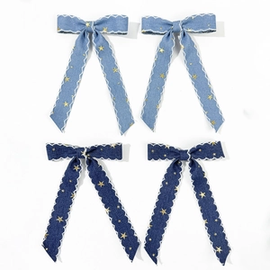 Détail de barrettes à nœuds en jean avec bords festonnés et motifs étoiles dorées