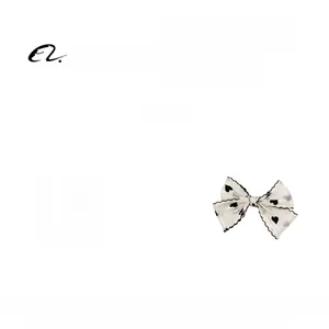 Detailed view of a white tulle hair bow clip featuring black heart patterns and lightweight fabric