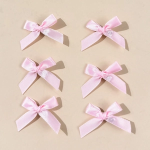 Detail showing six pink satin ballet bow hair clips in a neat 2x3 matrix arrangement