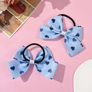 Détail de nœuds de cheveux bleus avec motifs de cœurs foncés sur fond rose