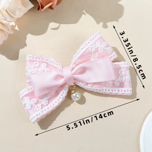 Detail view of a pink lace bow hair clip with pearl charm and 14cm size measurement