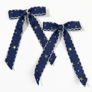 Vue détaillée des barrettes en denim avec étoiles et bordure en dentelle blanche