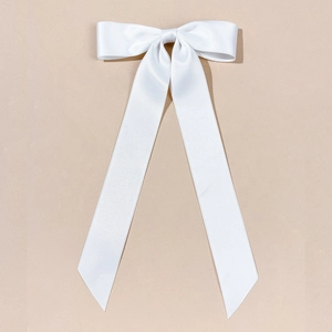 Détail du nœud papillon blanc en satin avec de longs rubans et une texture soyeuse