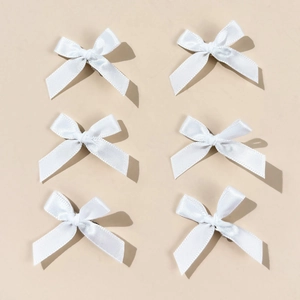 Detailed view of six white satin bow hair clips arranged neatly in a minimalist 2x3 layout