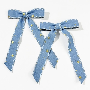 Détails des barrettes nœuds en denim bleu clair avec étoiles dorées et bords ondulés