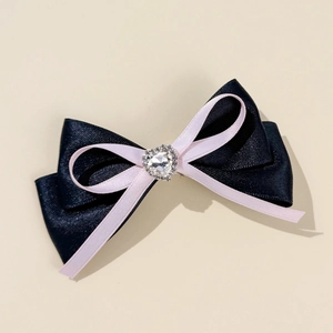 Detailed close-up of double-layer bow hair clip with heart-shaped crystal centerpiece