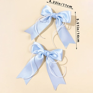 Macro shot of light blue satin bow hair clip featuring elegant double faux pearl chains