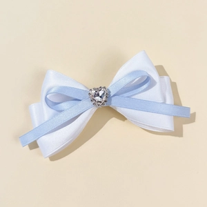 Detail of blue and white layered silk ribbon hair clip with a heart rhinestone