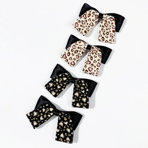 Set di quattro fermagli per capelli con stampa leopardata e cuori in beige e nero con fiocco