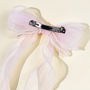 Detail of light pink organza hair bow clip with pearl trim and silver metal spring clip
