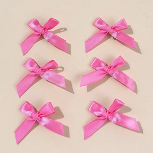 Close-up of 6 pack pink silk satin bow hair clips for women with smooth glossy texture