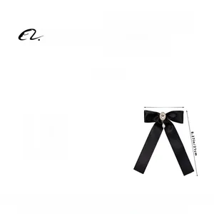 Detail of black ribbon bow hairclip with oval crystal and pearl pendant, 13cm x 21cm