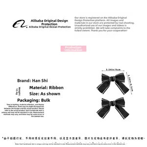 Detailed view of black ribbon bow hair clip with white trim and 9cm size measurement