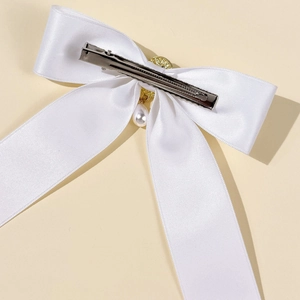 Detailed back view of white satin bow hair clip with pearl pendant and metal clasp