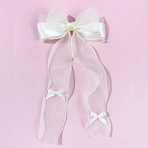 Detail of cream organza ribbon hair clip featuring satin rose and long flowing streamers