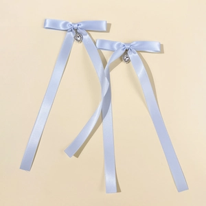 Détail de nœuds en satin bleu clair avec pendentifs cœurs en strass pour la coiffure