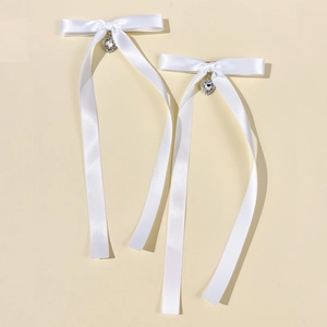 Détail d'un nœud en satin blanc orné d'un pendentif en strass en forme de cœur