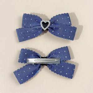 Détail de barrettes noeuds en denim à pois bleus avec strass et pince crocodile en métal