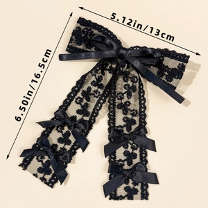 Detail view of a black lace bow hair clip with ribbons and exact size measurements