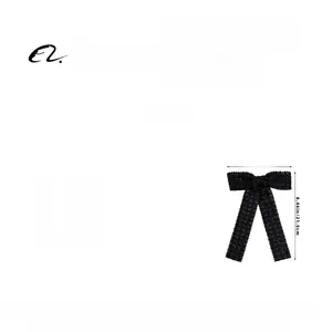 Detail view of black bow hair clip with dimensions of fifteen point five by twenty one point five cm