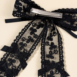 Detailed back view of a black lace bow hair clip showing the metal duckbill clip