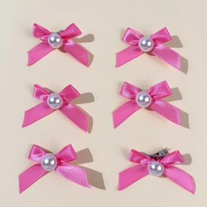 Détail de six barrettes à cheveux en satin rose avec perles et clips en métal