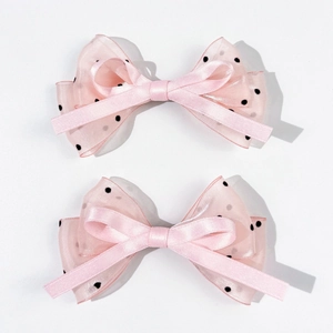 Vue détaillée de barrettes noeuds roses en tulle à pois et ruban de satin pour cheveux