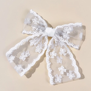 Detailed view of white lace bow hair clip with delicate embroidered butterfly patterns