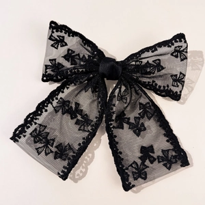 Detail of elegant black lace bow hair clip with fine mesh texture and French vintage style
