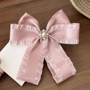 Fermaglio per capelli con fiocco di raso rosa, bordi arricciati, perle e strass