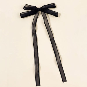 Détail d'un nœud à cheveux style ballet en organza noir avec bords plissés ondulés délicats